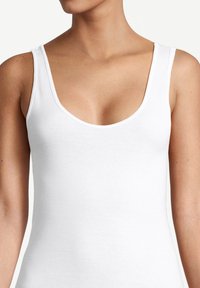 Top bianco senza maniche con scollatura a barca, spalline larghe e design aderente. Realizzato in morbido cotone elasticizzato.