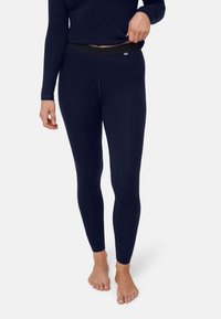 Mörkblå leggings av ett mjukt, elastiskt material med en kontrasterande svart midjeresår och en figurnära design.