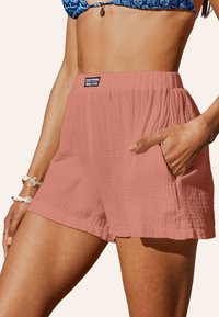 Roze shorts van een textuurstof, met een elastische tailleband en zakken. Etiket zegt "California Original Design." Casual, ontspannen pasvorm.