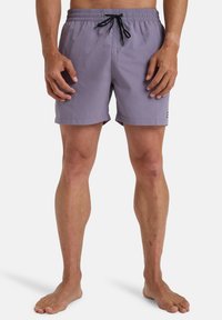 Shorts de bain violets clairs avec une taille élastique, cordon noir et un petit logo sur le côté. Tissu lisse et léger.