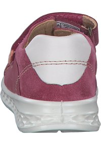 Rosa mockaskor med en vit gummisula, med en slät klack och justerbar rem. Synliga sömmar som accentuerar ovansidan och klacken.