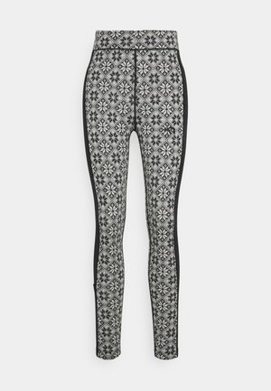 Leggings à motif noir et blanc, avec une coupe ajustée, taille haute et panneaux latéraux noirs contrastés avec un imprimé géométrique.