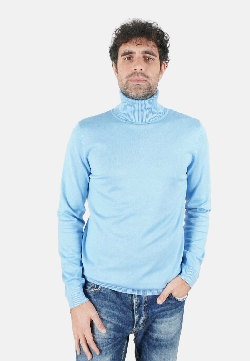 Maglione a collo alto azzurro realizzato in tessuto morbido e liscio, con collo e polsini a coste, abbinato a jeans blu.