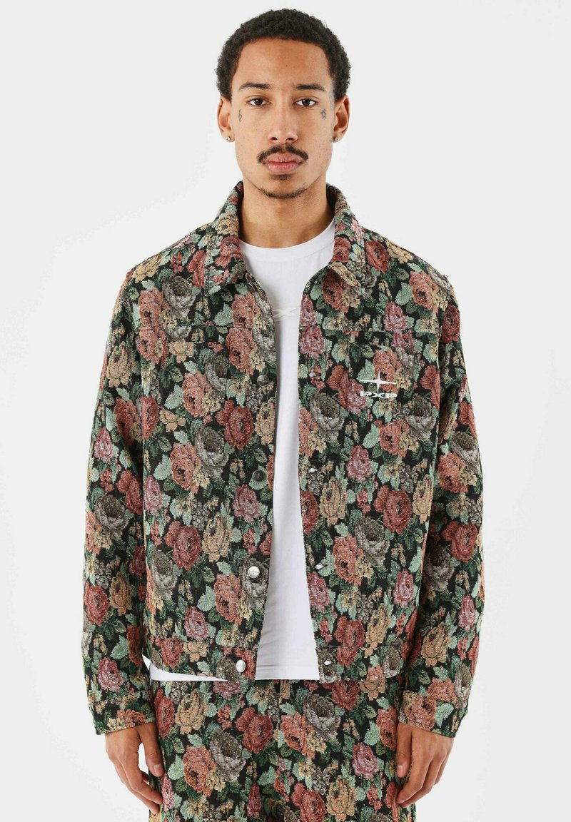 Blomstret denimjakke med en mørkegrøn baggrund og rosa, røde og gule roser, metalknaplukninger og en brystdetalje.