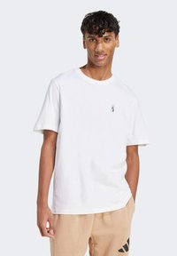 Biela bavlnená tričko s krátkymi ruk�ávmi a okrúhlym výstrihom. Obsahuje malú, detailne vykreslenú grafiku na oblasti ľavého hrudníka.