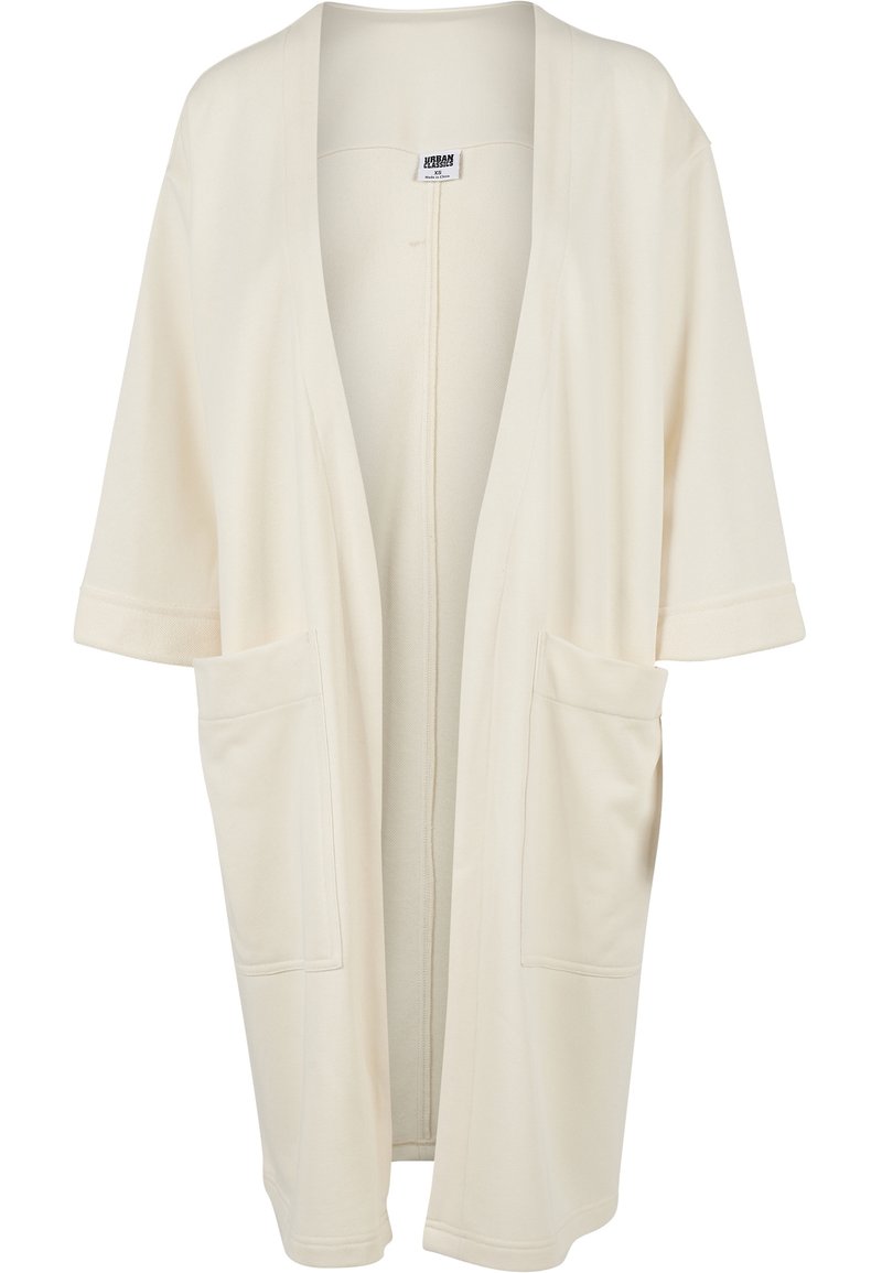 Beige kimono cardigan featuring a loose fit, short sleeves, open front, and two large front pockets. Soft fabric with no additional patterns.
