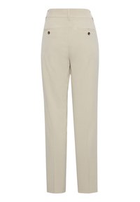 Pantaloni beige con una vestibilità su misura, caratterizzati da due tasche posteriori con bottoni marroni e un tessuto liscio e strutturato.