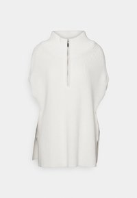 Pull sans manches blanc en maille avec un col montant et une fermeture éclair à l'avant, avec des fentes latérales et une texture côtelée.