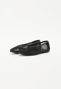 Black ballet flats with textured floral appliqués, a smooth fabric upper, and a flexible rubber sole, featuring an open design on the sides.