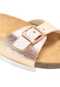 Rosa guld konstläder sandal med justerbar rem, metallspänne och korkfotbädd. Har ett präglat logotyp på remmen.