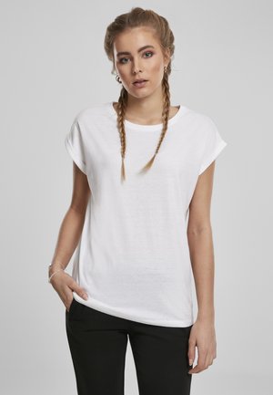 Hvid bomulds T-shirt med rullede ærmer, afslappet pasform og rund halsudskæring, parret med sorte bukser. Glat tekstur, enkelt design.