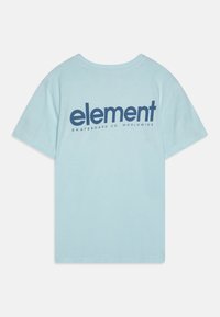 Camiseta de color azul claro con mangas cortas, que presenta un gran logo en color azul marino de "element" y el texto "SKATEBOARD CO. WORLDWIDE" en la parte de atrás.