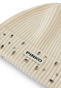 Cappello in maglia a costine color crema con decorazioni di colore argento e etichetta cucita "PINKO". Morbido al tatto, design aderente e dettagli decorativi.