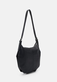 Sac à épaule en cuir noir avec une finition texturée, doté d'une seule sangle réglable et d'une fermeture zippée en haut.