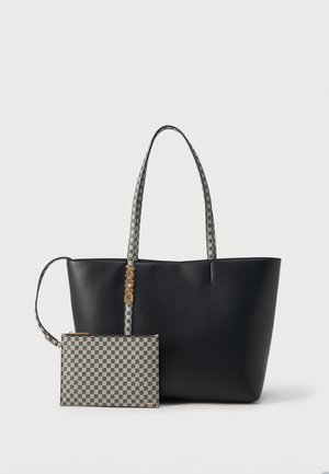 Sac cabas noir avec poignées grises à motifs et pochette grise à motifs attachée, présentant le logo DKNY répété et un charm doré avec initiales.