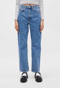 Jasnoniebieskie dżinsy z wysokim stanem o prostym kroju, z pomarańczowymi przeszyciami, pięciokieszeniowym designem i małym logo na tylnej kieszeni.