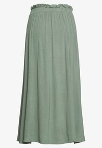 Vaaleanvihreä, polvipituinen hame, jossa on kerätty joustava vyötärö, sileä pinta ja lentävä muoto; valmistettu pehmeästä, joustavasta kankaasta.