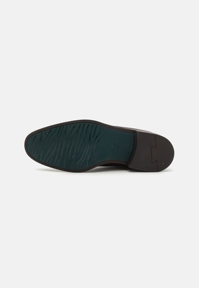 Semelle de chaussure en cuir marron avec un incrustation en vert foncé texturé. Présente une finition lisse et un motif de semelle pour une meilleure adhérence.