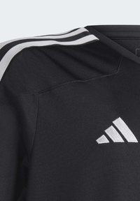 T-shirt de sport noir avec un design à col en V. Présente des bandes blanches à trois rayures sur les épaules et un logo brodé blanc en bas à droite.