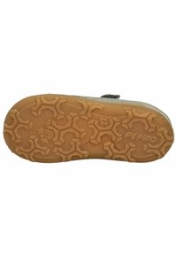 Suela de zapato de goma marrón con patrón texturizado de huellas de patas, en un color marrón claro. La suela tiene una forma redondeada y un diseño flexible.