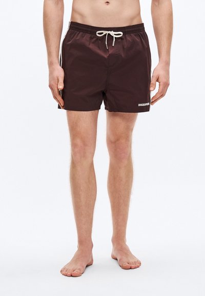 Shorts de bain marron en matériau léger, avec une taille à cordon, des poches latérales et un petit logo blanc sur la jambe gauche.