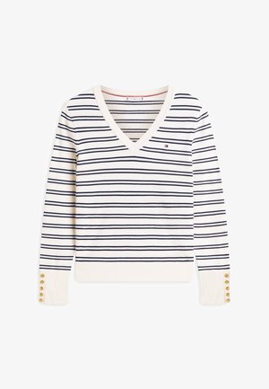 Kremfarvet langærmet V-hals trøje med tynde marineblå horisontale striber, lille logo på brystet og guldknapper på manchetterne.