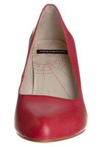 Chaussure à talon haute en cuir rouge avec un bout pointu et une surface lisse. À l'intérieur, elle présente une semelle intérieure de couleur claire avec un motif géométrique.