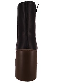 Botín de cuero negro hasta el tobillo con un tacón de plataforma grueso marrón y cremallera lateral. Presenta costuras visibles y una textura suave.