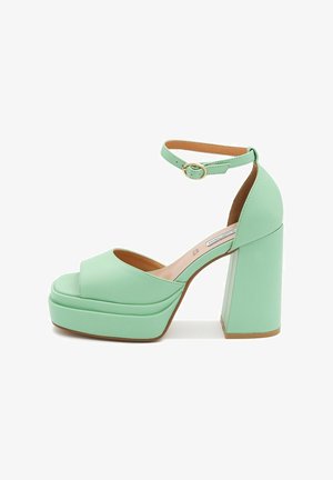 Sandali platform verdi menta con design a punta aperta, cinturino alla caviglia e tacco grosso. Finitura liscia con accenti minimi.