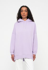 Sweatshirt lilás claro com capuz, corte solto, mangas longas e um pequeno logótipo em amarelo. Textura macia, fendas laterais na bainha.