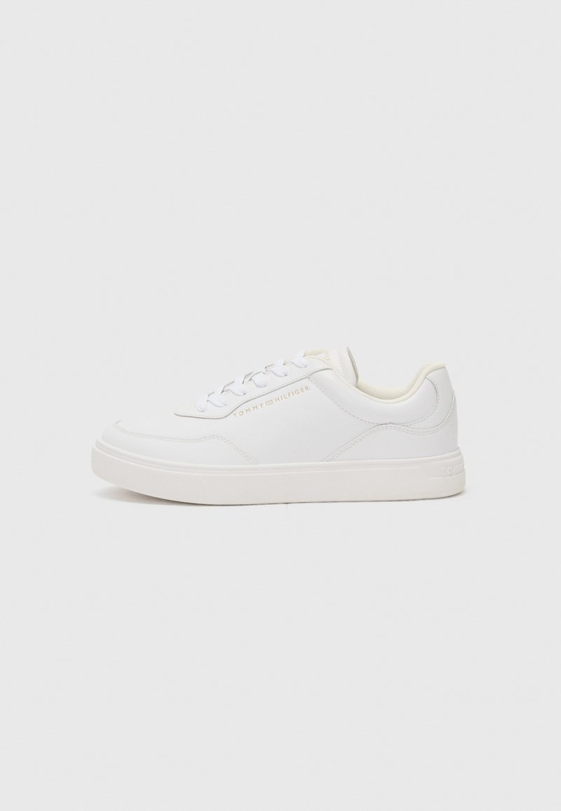 Sneaker bianca con una tomaia sintetica liscia, punta tonda, design con lacci e un logo discreto sul lato. Suola spessa e texture.