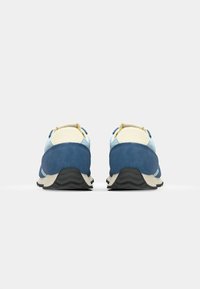 Blue and light blue suede sneakers with beige accents, layered design, cushioned collar, and textured black rubber sole.