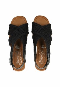 Schwarze gewebte Riemchensandalen mit Kreuzträgern, einer hellbraunen Innensohle und einem seitlichen Schnallendetail. Aus veganem Material, offenes Zehendesign.