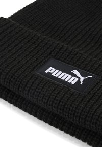 Berretto nero lavorato a maglia con texture a coste e un'etichetta rettangolare nera con il logo "PUMA" bianco e un grafiche di un gatto che salta.
