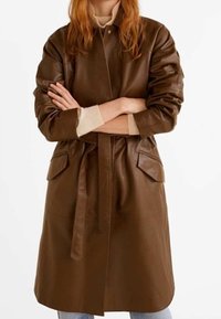 Bruine leren jas met een ceintuur in de taille, twee voorzakken en een gladde textuur. Kenmerkt zich door een kraag en een licht oversized pasvorm.