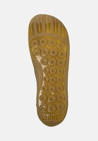 Soletta in gomma traslucida di colore giallo chiaro, con motivi circolari e scanalature per la presa, con il marchio impresso sul tallone.