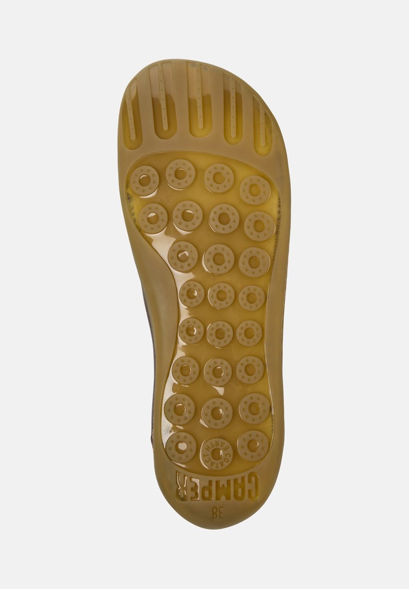 Translucente Gummisohle in Hellgelb, mit kreisförmigen Mustern und Rillen für Grip, mit geprägt Markenlogo an der Ferse.
