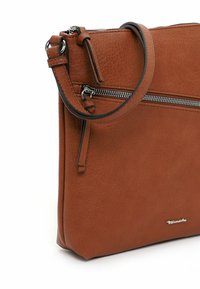 Borsa a tracolla in pelle marrone con texture liscia, dotata di una cerniera argentata e di una tracolla removibile. Design compatto dallo stile minimalista.