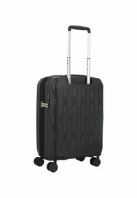 Maleta rígida negra con patrón geométrico, cuatro ruedas giratorias, asa retráctil plateada y cerradura de combinación incorporada en el lateral.
