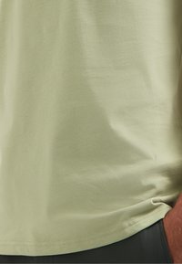 Lichtgroen T-shirt met korte mouwen, gemaakt van zachte stof, met een gladde textuur en een nette zoom aan de onderkant. Eenvoudig ontwerp.