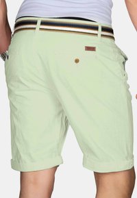 Light green cotton shorts with rolled cuffs, featuring a brown button and a multi-striped waistband with gold, blue, and black accents.
