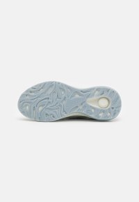 Shoe sole in light blue rubber with intricate swirling patterns and cutouts, featuring a textured surface for grip and flexibility.