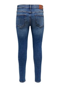 Siniset kapea lahkeiset farkut, joissa on kaksi takataskua, haalistuneet yksityiskohdat ja ruskea nahkainen merkkitunnus vyötäröllä, nähtynä takaa.