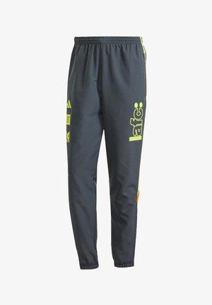 Dark gray athletic pants made from lightweight material. Features neon yellow branding and accents. Elastic waistband and tapered leg design.