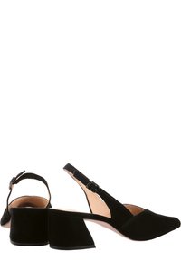 Escarpins slingback en suède noir avec un bout pointu, un talon épais et une bride réglable autour de la cheville. Texture lisse et détails de design minimalistes.