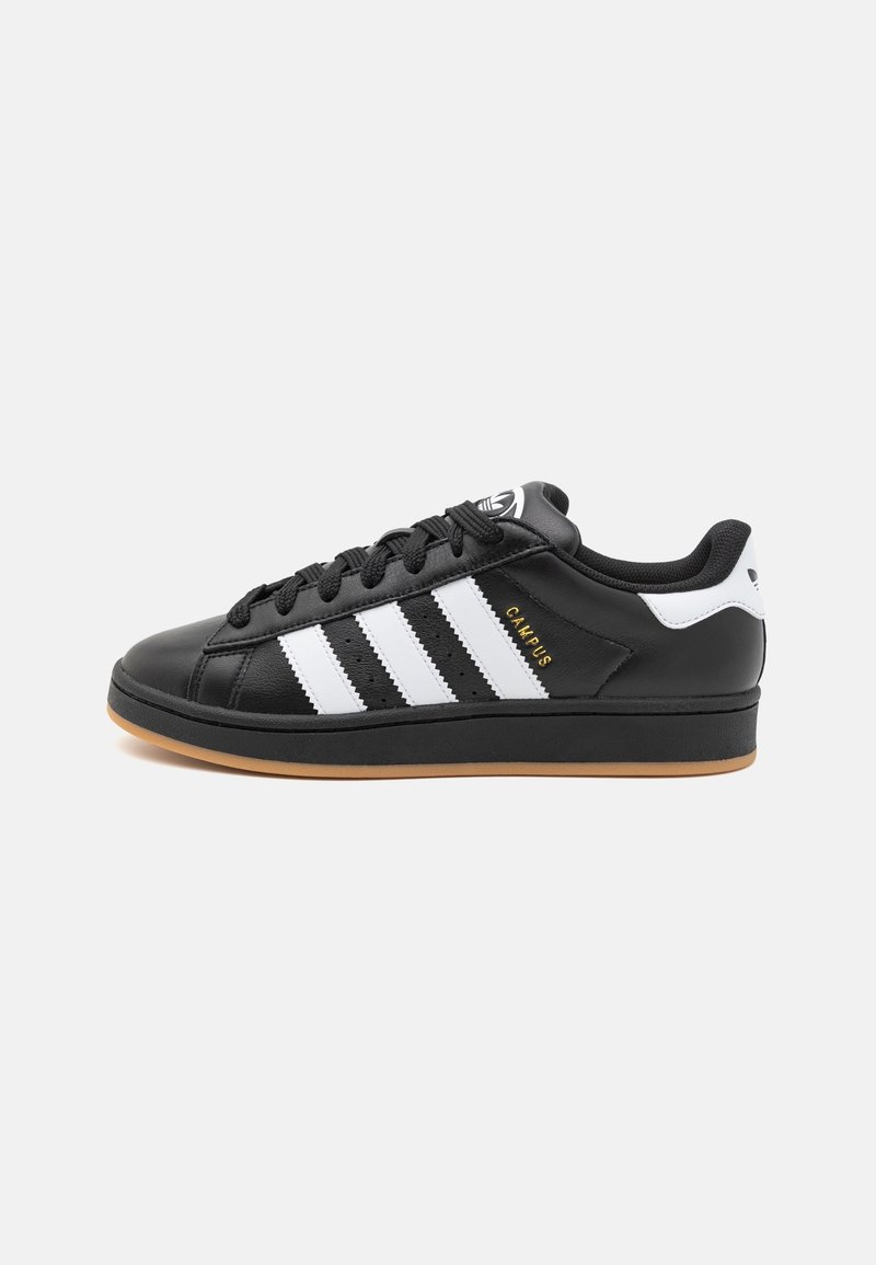 Baskets Adidas Campus noires avec des bandes blanches, semelle en gomme, lacets noirs et languette de talon blanche.