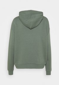 Sudadera verde oliva lisa vista desde atrás, con mangas largas, capucha y puños y dobladillo de canalé.