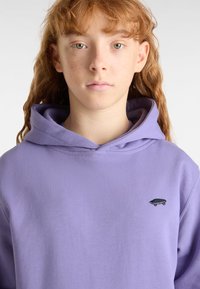 Lavendel Kapuzenpullover mit einer vorderen Kängurutasche, einer verstellbaren Kapuze und einem kleinen Skateboard-Logo auf der linken Brust. Weicher Baumwollmischgewebe.