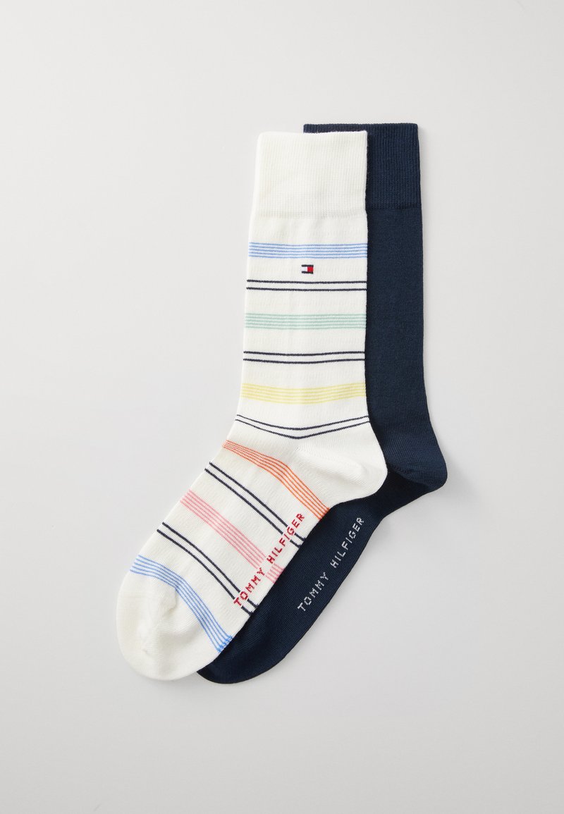 Gestreepte sokken in wit en marineblauw, met multikleurige strepen in rood, groen, geel en blauw, en logodetail bij de enkel.