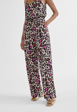 Pantalones de pierna ancha con estampado de leopardo en tejido suave, con acentos en rosa y rojo. Combinados con una blusa sin mangas a juego y calzado dorado.